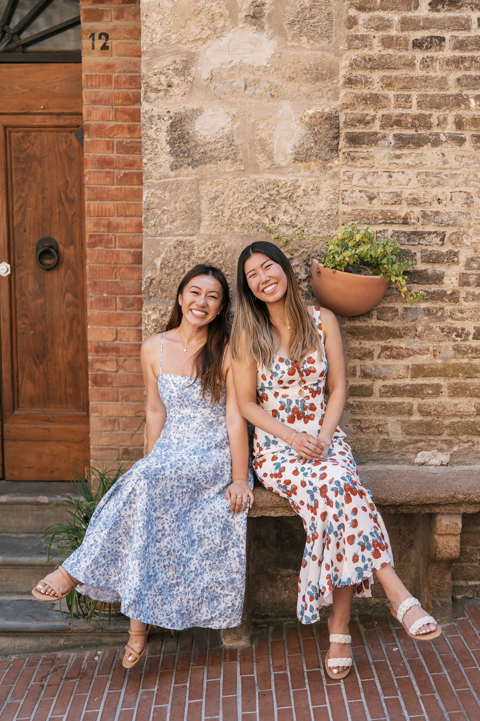 Two sisters smiling during a travel photoshoot in an Italian village